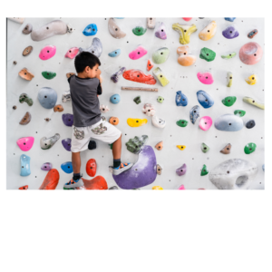 A kid climbing a colorful rock wall that represents Maslow's hierarchy of needs and finding solutions for homeschooling.