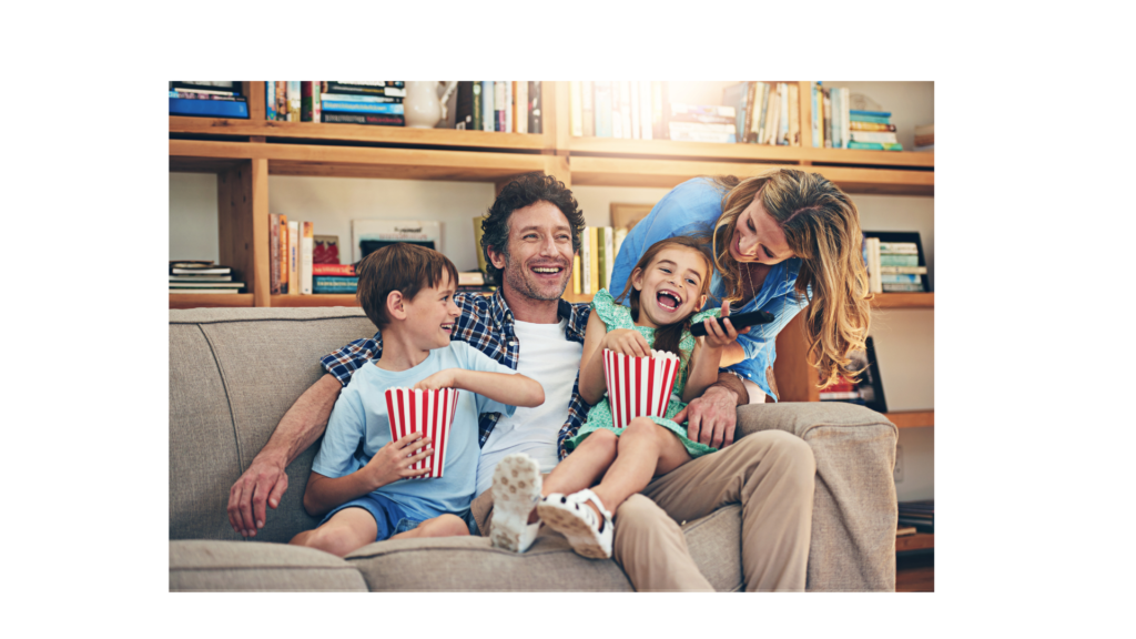 A family watching a movie based on a book they have been reading in the summer.