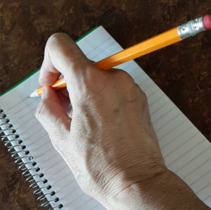 An alternative pencil grip between pointer and middle fingers.